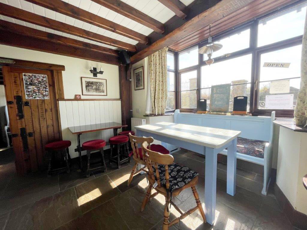 Lot: 98 - SEAFRONT PUBLIC HOUSE WITH STUNNING VIEWS AND OWNER/MANAGER LIVING ACCOMMODATION OVER - A seating alcove at the front of the building